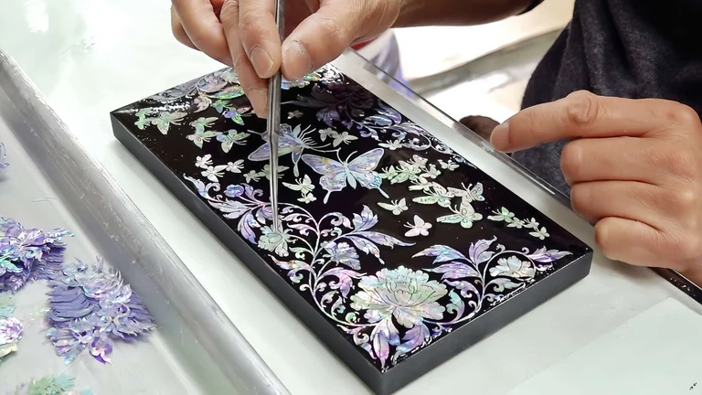Mother-of-pearl inlay being arranged by hand