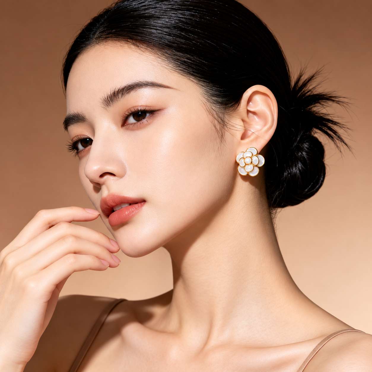 Flower-shaped mother-of-pearl earring shown on the ear from the front