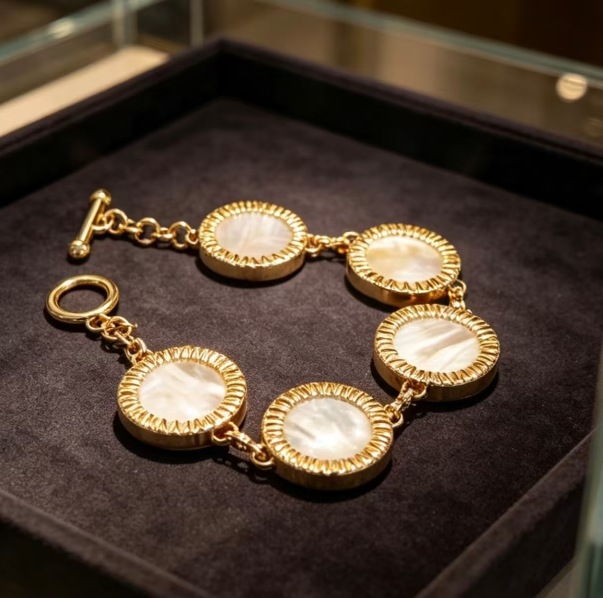 Five mother-of-pearl disc bracelet laid across an open jewellery box