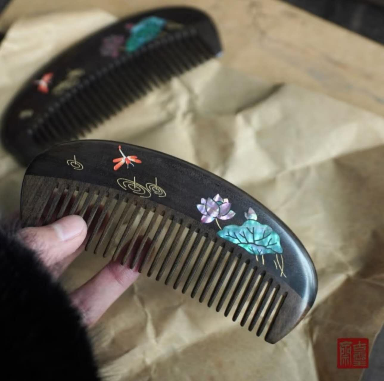 Two dark wood combs with lotus and dragonfly shell inlay