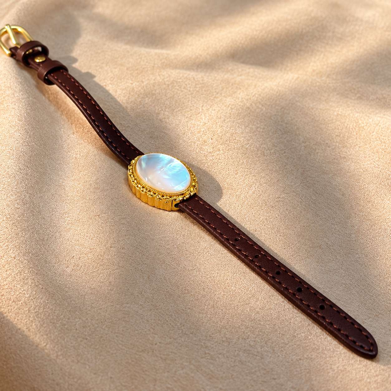 Full brown leather strap of the mother-of-pearl bracelet shown with the buckle