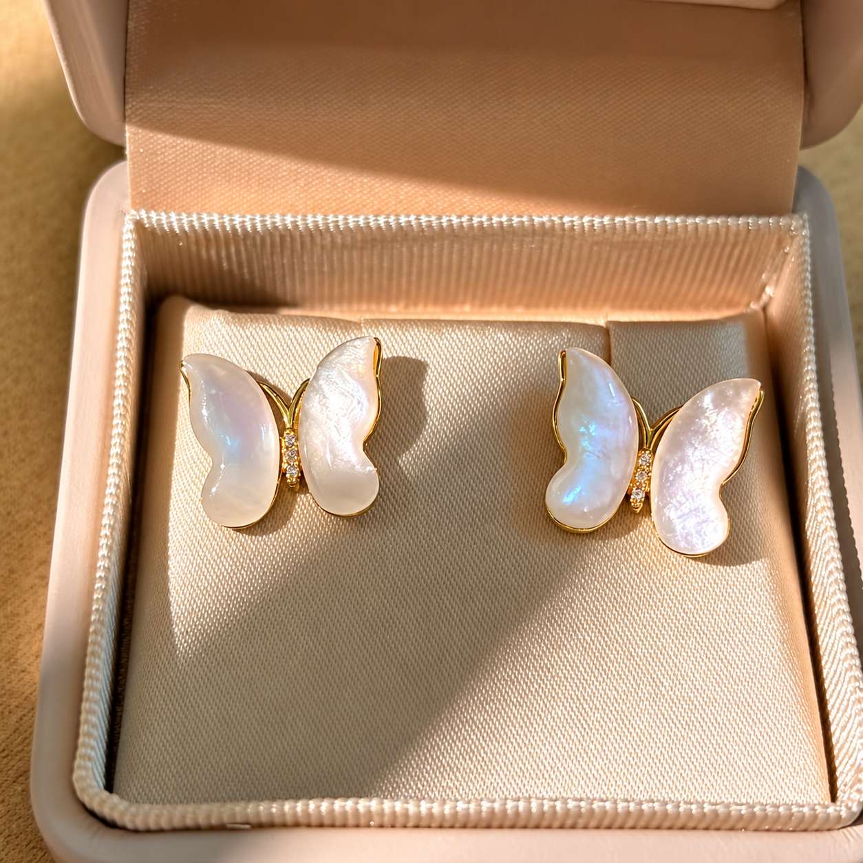 Butterfly mother-of-pearl earrings displayed inside an open jewellery box